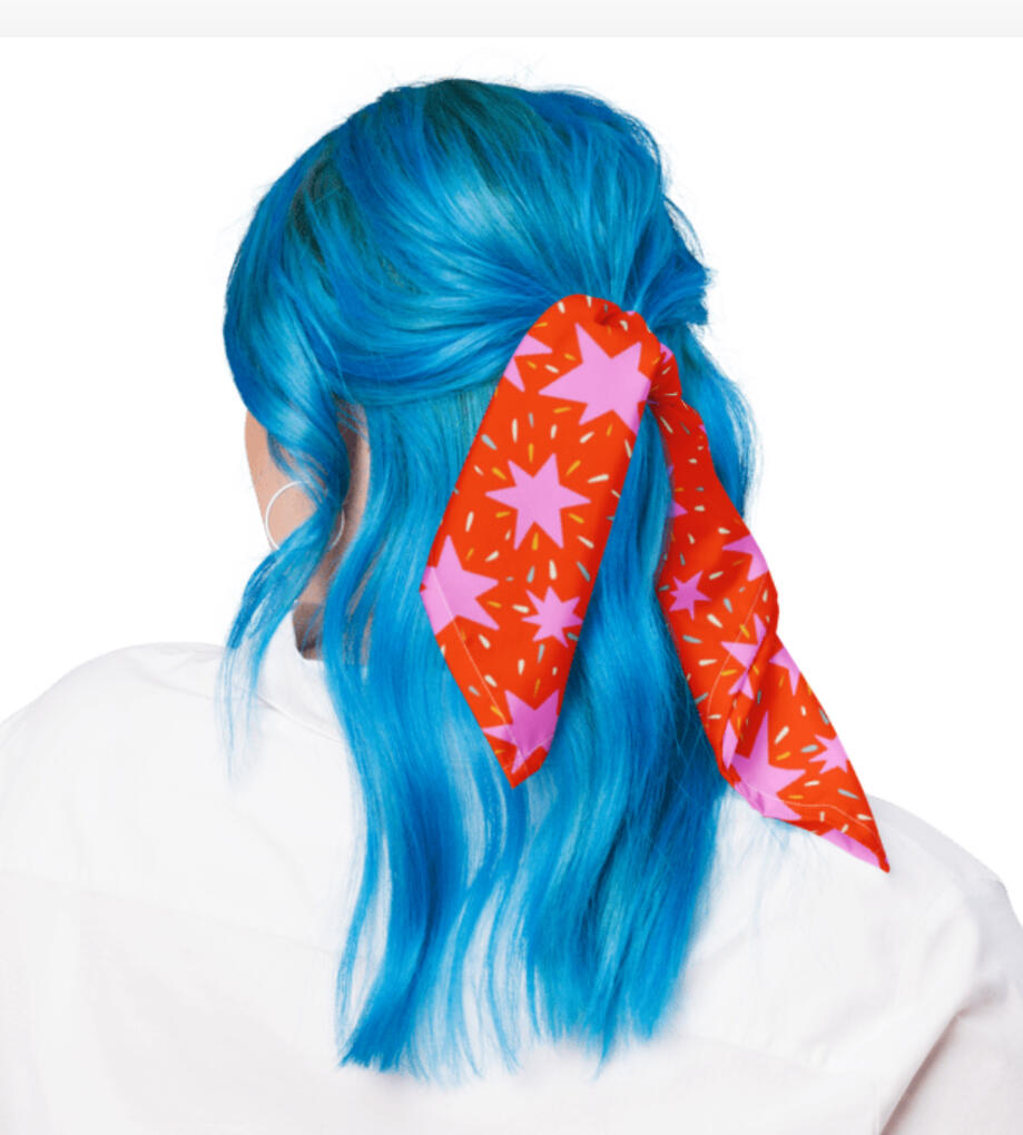 Silk bandanna hair ribbon in red and pink starburst pattern.